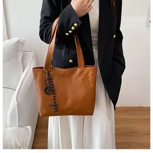 Détail du sac cabas en cuir PU marron avec étiquette FASHION et anneau tressé
