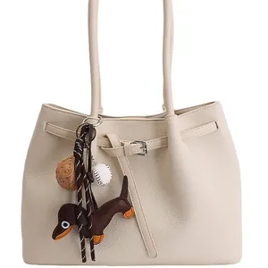Cremeweiße Handtasche aus Litschileder mit Dackelanhänger und Baseball-Accessoires