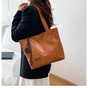 Détail d'un cabas en cuir PU marron avec étiquette Fashion et cordon tissé