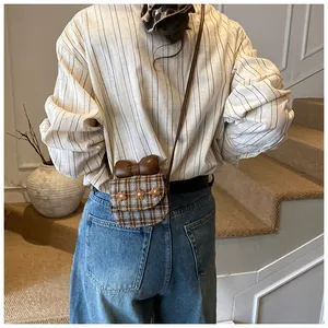 Detailed back view of a mini plaid crossbody bag with a brown leather bow and floral accents