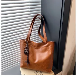 Gros plan d'un sac cabas en similicuir marron avec texture plissée et fines bretelles