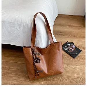 Détails d'un cabas vintage marron avec texture cuir et pendentif biscuit décoratif