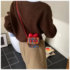 Detailed back view of a mini plaid crossbody bag with red bow and flower details
