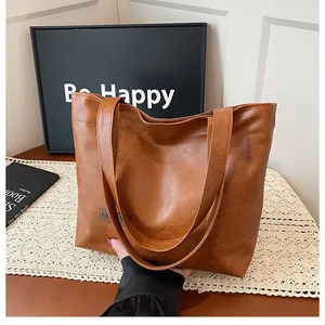 Détail du sac cabas marron avec patch fashion et bandoulières résistantes pour le quotidien