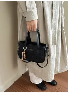 Gros plan du sac noir à texture ondulée avec pendentif de perles bohèmes chic