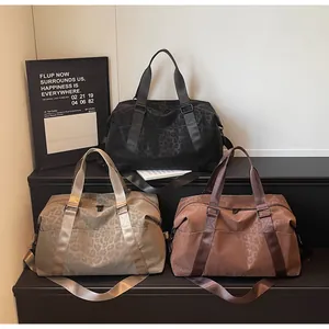 Close-up of leopard print travel bags in three colors with adjustable shoulder straps