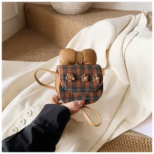 Detail of cute checkered mini crossbody bag with a large bow and floral accents