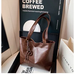 Vue détaillée du sac cabas marron foncé vintage avec cordon à pompon et boucle métallique