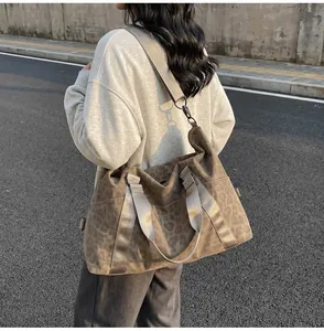 Detail of large brown shoulder bag with leopard pattern and sturdy metal hardware