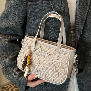 Sac à main tissé beige pour femme avec pendentif en perles de bois et plaque métallique chic