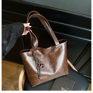 Détail du sac cabas marron foncé avec étiquette de mode et accessoire anneau noué