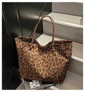 Detail of winter leopard print suede tote bag with brown leather straps and metal buckles