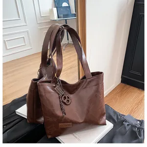 Détail du sac cabas marron foncé en cuir ciré avec breloque anneau métallique