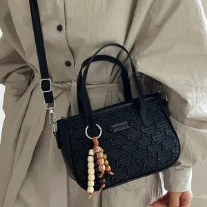 Sac à bandoulière noir tendance avec gaufrage en étoile et breloque en perles