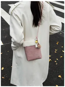 Sac bandoulière en daim rose avec bordure en peluche blanche et breloques en automne