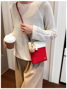 Détail du sac à bandoulière en peluche rouge et blanc avec breloques étoile et chiot