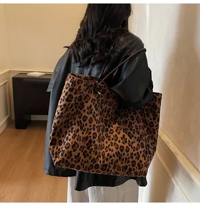 Lifestyle shot of large leopard print tote bag with brown straps worn on shoulder