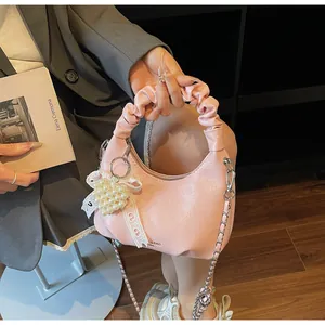 Pink pleated hobo bag with pearl heart charm and lace detail shown in a lifestyle scene