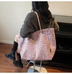 Detail of pink leopard print tote bag featuring MULAIDI brand label and soft fabric texture