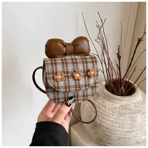 Close-up of plaid fabric bag with large faux leather bow and floral details