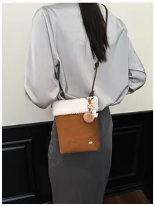 Détail du sac bandoulière en peluche avec pendentif chien mignon sur l'épaule du mannequin