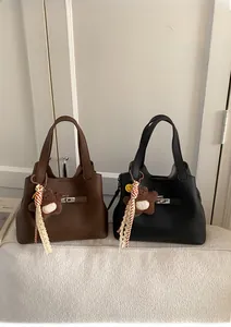 Detail view of retro bucket bags in brown and black leather with metal twist locks