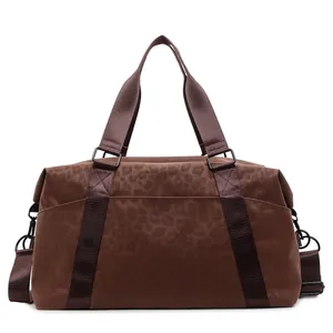 Large dark brown leopard print travel bag with reinforced handles and shoulder strap