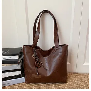 Détail du sac cabas marron foncé avec texture grainée et étiquette Fashion chic