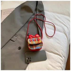 Mini checkered crossbody bag with red bow and flowers shown next to a phone for size comparison
