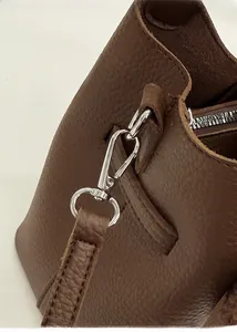 Detail of silver metal buckle and brown leather strap on vintage bucket bag
