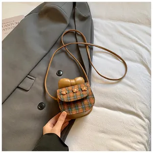 Close-up of vintage brown plaid crossbody bag with 3D bow and floral details