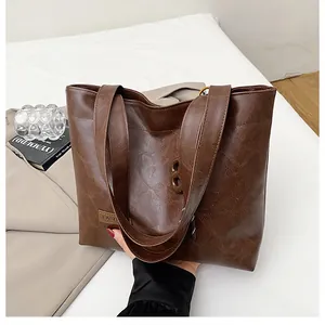 Détail du grand sac cabas marron foncé avec texture cuir craquelé et étiquette