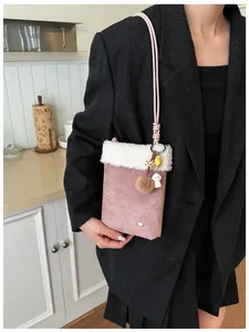 Détail du mini sac en simili daim rose avec bordure en fourrure et breloques chien