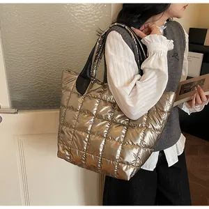 Borsa tote trapuntata champagne metallizzato con cinturini neri indossata da una modella