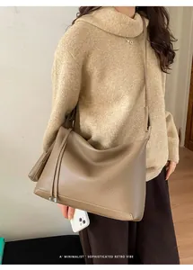 Detail shot of khaki leather tote bag featuring a minimalist retro vibe on a model
