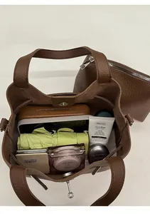 Detail of brown litchi leather bucket bag showing large capacity and inner pouch