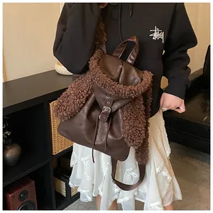 Detail of dark brown faux leather backpack with plush sheepskin fleece texture and flap