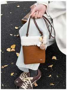 Détail du sac bandoulière en peluche avec similicuir et bordure en peau de mouton douce