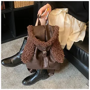 Detail of dark brown faux leather backpack with plush sheepskin ears held by a model