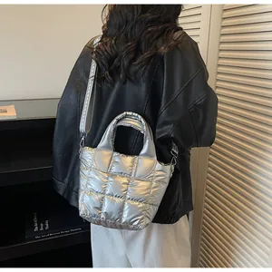Borsa a secchiello trapuntata argento con tracolla indossata da una modella in studio