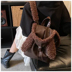 Detail view of a dark brown faux leather backpack with plush bunny ears and furry straps