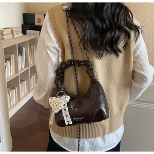 Close-up of pleated handle handbag with lace bow and pearl heart charm detail