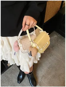 Détails des sacs à pois roses et jaunes avec dentelle et breloques en cœur en peluche