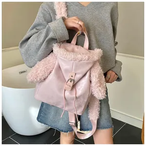 Detail of pink faux shearling trim on a leather backpack with drawstring closure