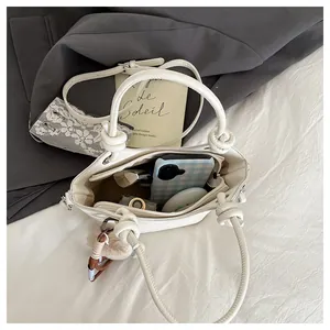 Internal view of cream bucket bag showing space for phone, lipstick, and plush charm