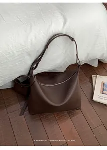 Detail of dark brown pebbled leather hobo bag with adjustable strap and mini pouch