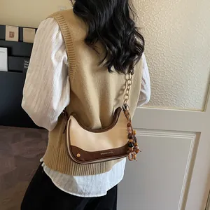 Chic beige canvas and brown leather crossbody saddle bag with gold chain and beads
