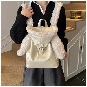 Detail of faux fur trim and silver buckle on a stylish cream plush backpack
