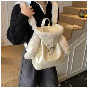 Detail of off-white faux leather backpack with plush shearling trim and metal buckle