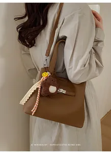 Detail of brown litchi pattern bucket bag with silver buckle and decorative charms